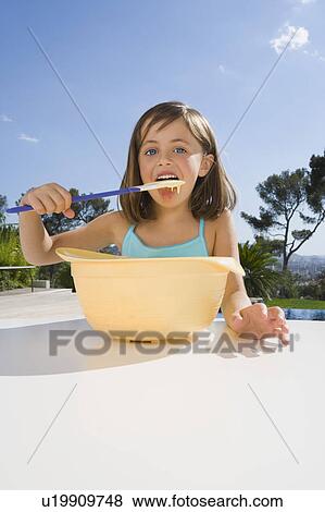 Young girl eating cream. View Large Photo Image Stock Photo - Young girl eating cream.. Fotosearch