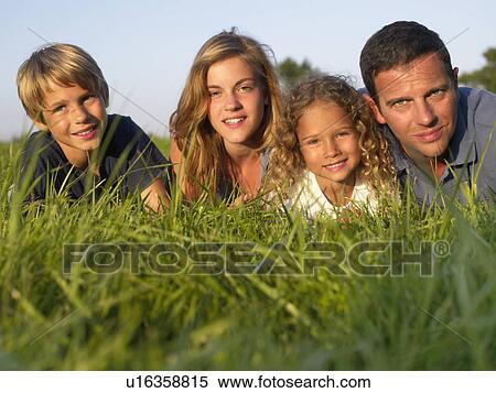 Family lying in a field. View Large Photo Image Stock Photography - Family lying in a field.. Fotosearch
