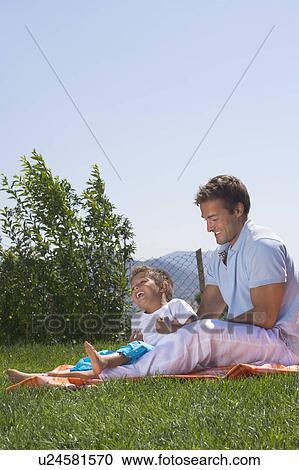 Father and son playing on a picnic rug. View Large Photo Image Stock Image - Father and son playing on a picnic rug.. Fotosearch