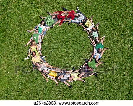 Group lying on grass in a circle View Large Photo Image Stock Image - Group lying on grass in a circle. Fotosearch