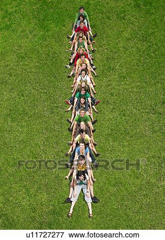 Group sitting in a line on the grass View Large Photo Image Stock Photo - Group sitting in a line on the grass. Fotosearch