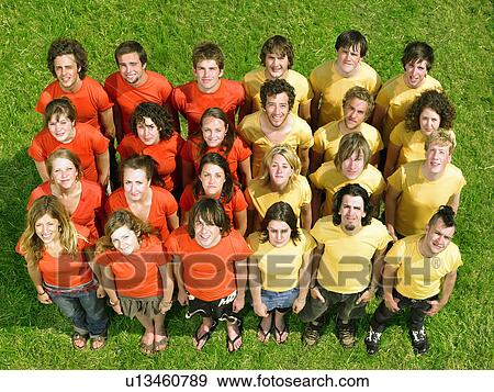 Group standing on grass half wearing orange half yellow View Large Photo Image Stock Photo - Group standing on grass half wearing orange half yellow. Fotosearch