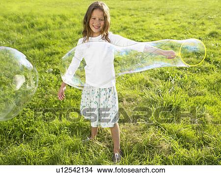 Little girl making soap bubbles. View Large Photo Image Picture - Little girl making soap bubbles.. Fotosearch
