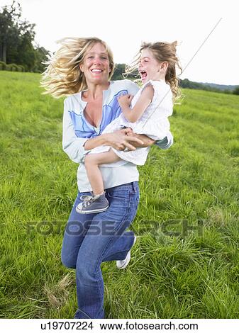 Picture - Mother and daughter playing in a field.. Fotosearch