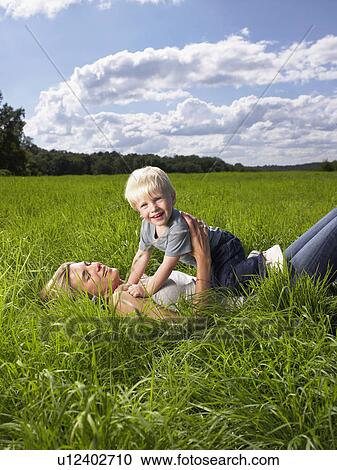 Mother and son playing in a field. View Large Photo Image Stock Image - Mother and son playing in a field.. Fotosearch