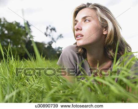 Woman laying in a green field portrait. View Large Photo Image Stock Photo - Woman laying in a green field portrait.. Fotosearch