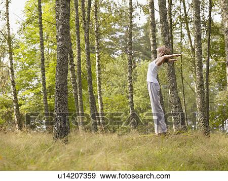 Woman standing on large rock in forest with arms outstretched. View Large Photo Image Stock Photo - Woman standing on large rock in forest with arms outstretched.. Fotosearch