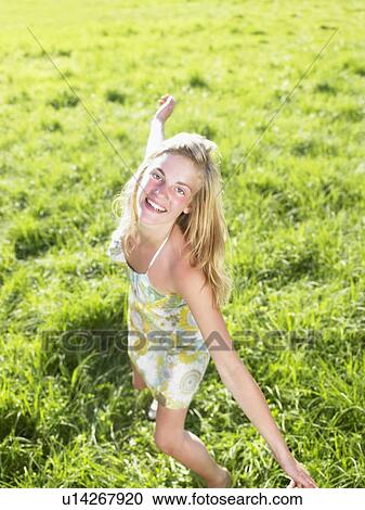 Young woman dancing in a green field. View Large Photo Image Stock Image - Young woman dancing in a green field.. Fotosearch