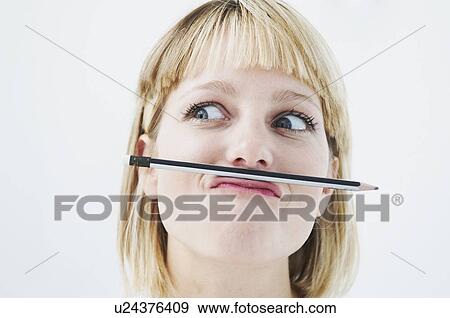 Stock Photo - Amusing woman with pencil above mouth. Fotosearch