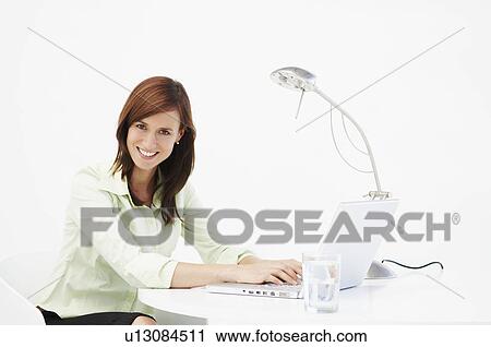 Stock Image - Business woman at desk . Fotosearch