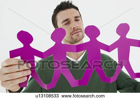 Businessman considers paper figures View Large Photo Image Stock Image - Businessman considers paper figures. Fotosearch