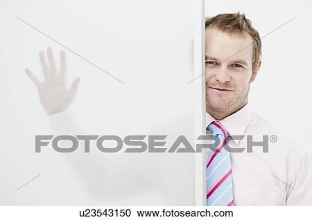 Stock Image - Businessman with hand on glass panel. Fotosearch
