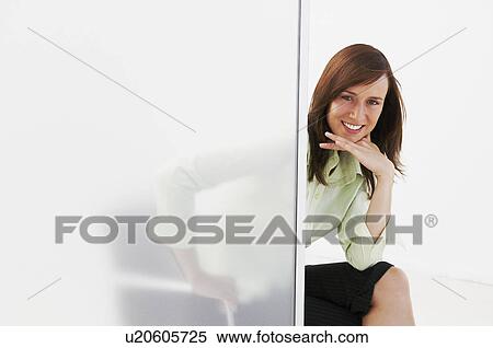 Confident woman looking round screen View Large Photo Image Stock Photography - Confident woman looking round screen. Fotosearch
