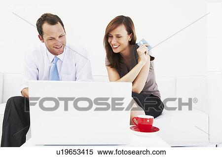 Couple on sofa purchase on-line View Large Photo Image Stock Photography - Couple on sofa purchase on-line. Fotosearch