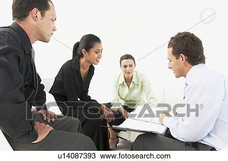 Stock Image - Four people in office meeting. Fotosearch