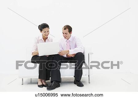 Man and woman smiling at laptop View Large Photo Image Stock Photography - Man and woman smiling at laptop. Fotosearch