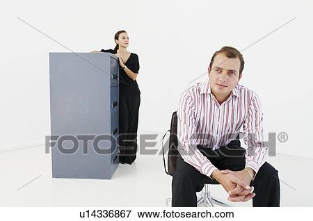 Man looks to camera, woman in background View Large Photo Image Stock Photo - Man looks to camera, woman in background. Fotosearch