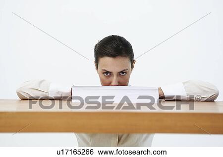Stock Photograph - Portrait of woman looking over paper. Fotosearch