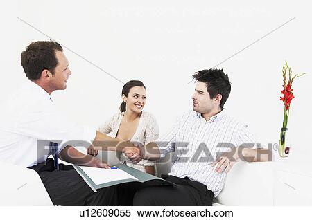 Salesman shakes hands with couple View Large Photo Image Stock Photography - Salesman shakes hands with couple. Fotosearch