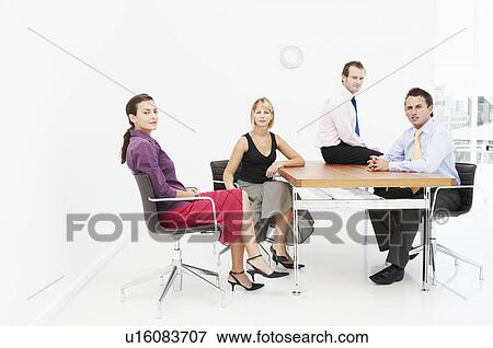 Seated business people look to camera View Large Photo Image Stock Photo - Seated business people look to camera. Fotosearch