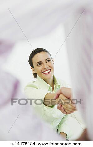 Smiling woman shaking hands View Large Photo Image Picture - Smiling woman shaking hands. Fotosearch