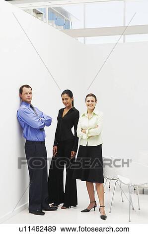Three business people standing in office View Large Photo Image Stock Photo - Three business people standing in office. Fotosearch