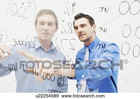 Two men write on glass panel View Large Photo Image Stock Photo - Two men write on glass panel. Fotosearch