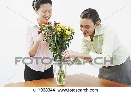Picture - Two woman watering flowers. Fotosearch
