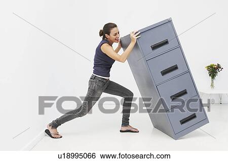 Woman struggles with filing cabinet View Large Photo Image Stock Photograph - Woman struggles with filing cabinet. Fotosearch