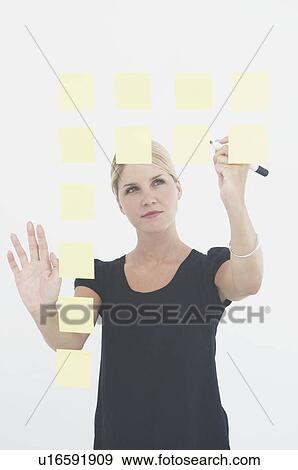 Woman writing notes on glass wall View Large Photo Image Stock Photo - Woman writing notes on glass wall. Fotosearch