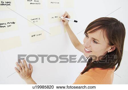 Woman writing notes on wall View Large Photo Image Stock Image - Woman writing notes on wall. Fotosearch
