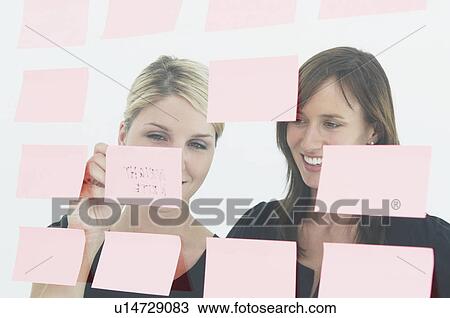 Women writing notes on glass wall View Large Photo Image Stock Image - Women writing notes on glass wall. Fotosearch