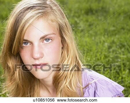 Stock Photograph - Young woman sitting in a field.. Fotosearch