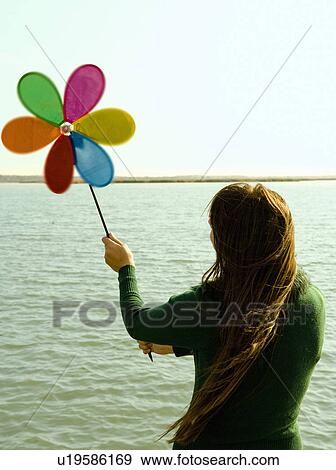 Girl holding up toy windmill rear view. View Large Photo Image Stock Photo - Girl holding up toy windmill rear view.. Fotosearch