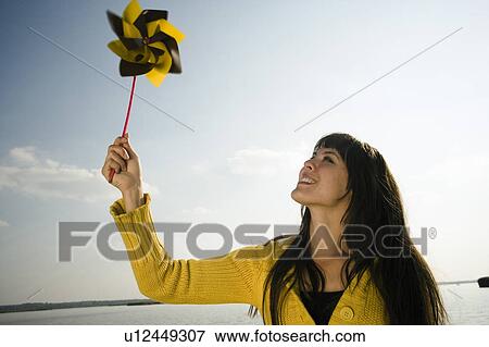 Girl holding up toy windmill. View Large Photo Image Stock Photo - Girl holding up toy windmill.. Fotosearch