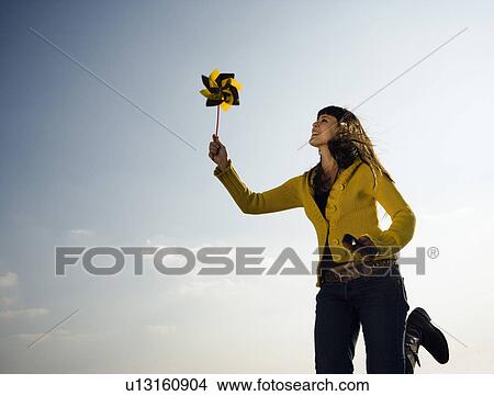 Girl running with toy windmill. View Large Photo Image Picture - Girl running with toy windmill.. Fotosearch