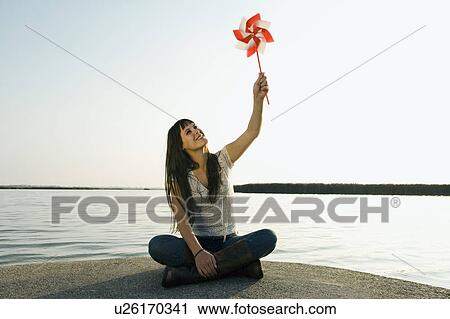 Woman holding toy windmill up in the air. View Large Photo Image Stock Image - Woman holding toy windmill up in the air.. Fotosearch