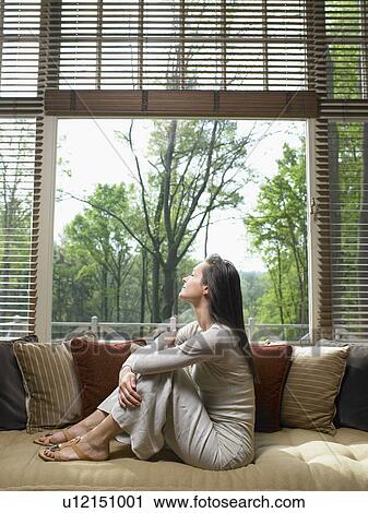 Woman with eyes closed sitting on sofa in living room. View Large Photo Image Stock Image - Woman with eyes closed sitting on sofa in living room.. Fotosearch