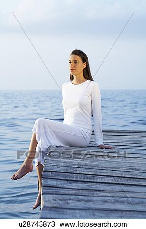Young woman sitting on dock looking at sea. View Large Photo Image Stock Image - Young woman sitting on dock looking at sea.. Fotosearch