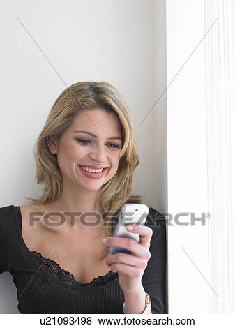 Young woman using mobile phone, smiling View Large Photo Image Stock Photo - Young woman using mobile phone, smiling. Fotosearch