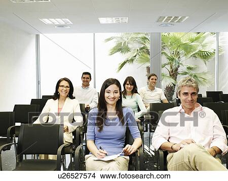 Picture - Colleagues watching presentation, smiling, portrait. Fotosearch