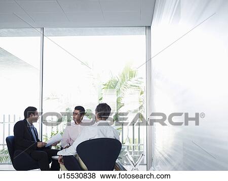 Stock Photo - Three businessmen having meeting in office. Fotosearch
