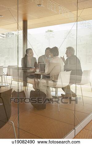 Two businessmen and two businesswomen having meeting in café, shot through window. Alicante, Spain. View Large Photo Image Stock Image - Two businessmen and two businesswomen having meeting in café, shot through window. Alicante, Spain.. Fotosearch