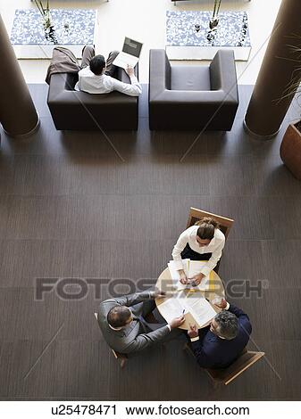 Two businessmen and woman having meeting, overhead view View Large Photo Image Stock Image - Two businessmen and woman having meeting, overhead view. Fotosearch