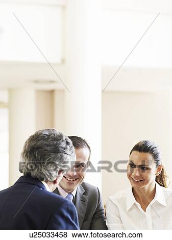 Two businessmen and woman in meeting, smiling View Large Photo Image Stock Photo - Two businessmen and woman in meeting, smiling. Fotosearch