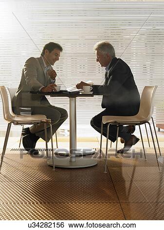 Stock Photograph - Two businessmen having meeting in a café. Alicante, Spain.. Fotosearch