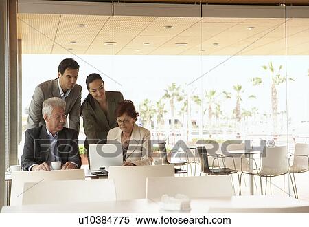 Two men and two women having a business meeting in a café, looking at laptop. Alicante, Spain. View Large Photo Image Stock Photography - Two men and two women having a business meeting in a café, looking at laptop. Alicante, Spain.. Fotosearch