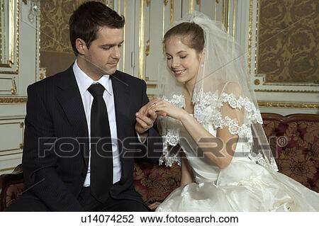 Bride and groom looking at ring View Large Photo Image Stock Image - Bride and groom looking at ring. Fotosearch
