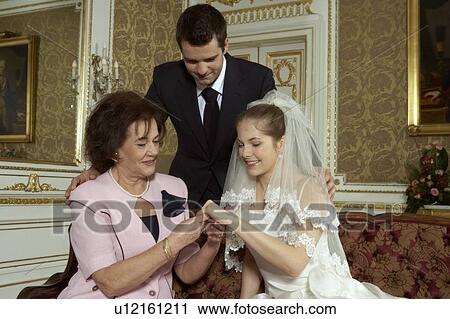 Bride, Groom and brides Mother looking at wedding ring View Large Photo Image Stock Image - Bride, Groom and brides Mother looking at wedding ring. Fotosearch