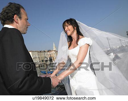 Groom and bride holding hands. Grand Canal, Venice, Italy. View Large Photo Image Stock Image - Groom and bride holding hands. Grand Canal, Venice, Italy.. Fotosearch